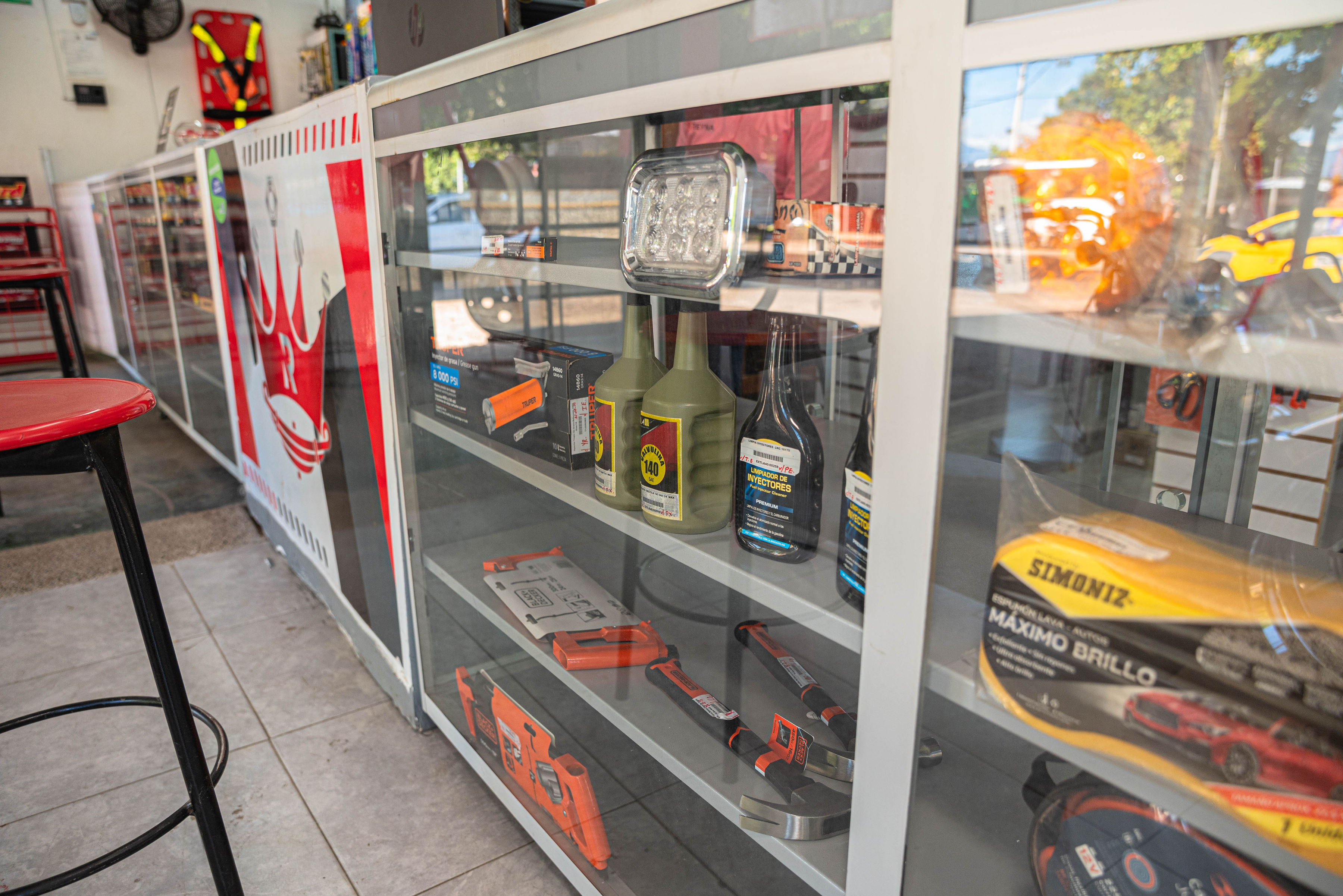 Vitrina de La Casa de La 40 con lubricantes, herramientas y accesorios automotrices en exhibición